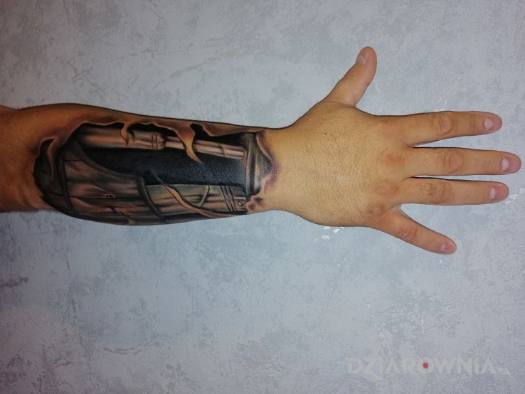 Tatuaż robót 2 w motywie rozdarta skóra i stylu biomechanika na przedramieniu