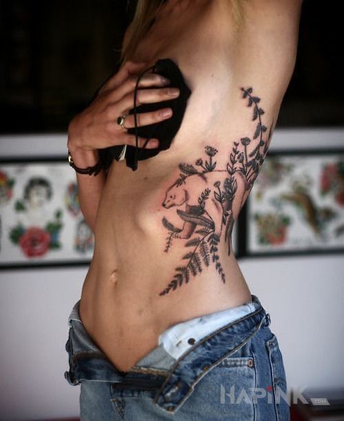 Tattoo Niedzwiadek polarny in flowers motif and graphic / illustrative style on the ribs