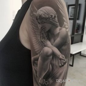 Tatuaż Anioł spętany kajdanami na ramieniu motyw: czarno-szare