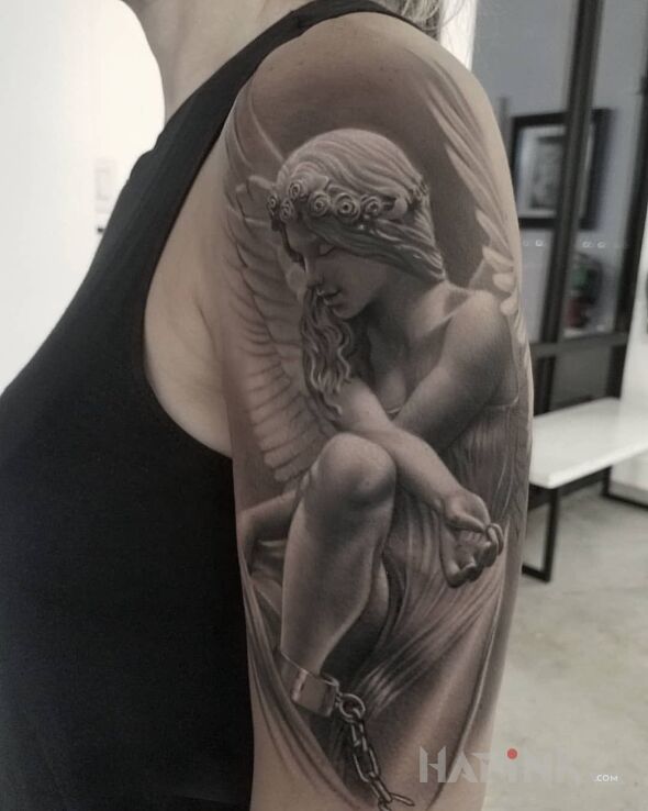 Tattoo Anioł spętany kajdanami in black and gray motif on the upper arm