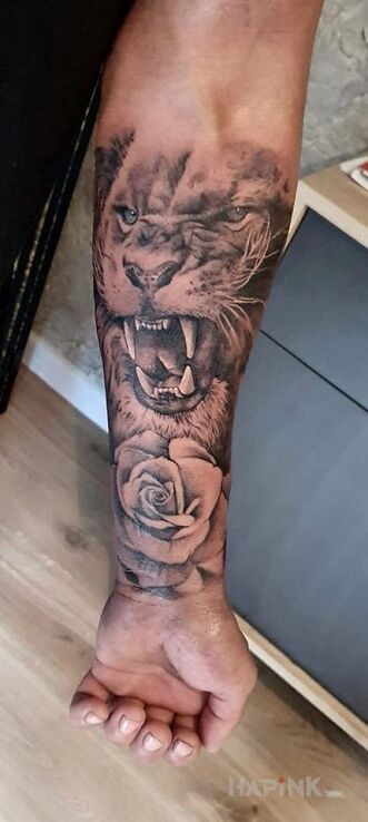 Tattoo Wkurzony lew in animals motif and realistic style on the forearm