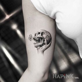 Tattoo Small skull on the upper arm motif: skulls style: graphic / illustrative