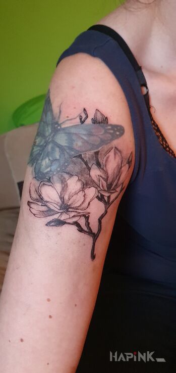 Tattoo Magnolia in butterflies motif and graphic / illustrative style on the upper arm
