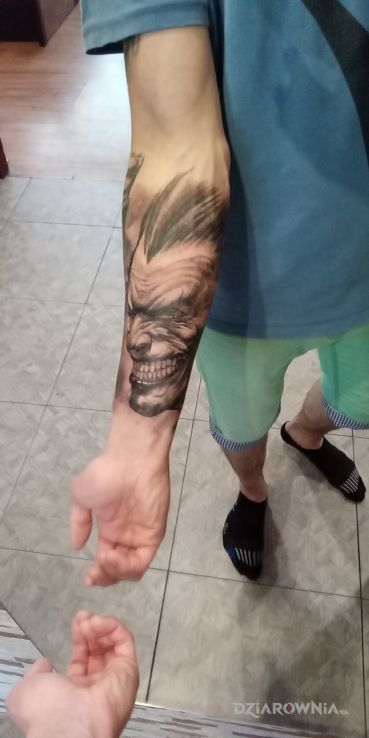 Tatuaż joker w motywie czarno-szare i stylu realistyczne na przedramieniu