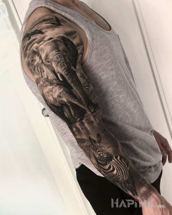 Tattoo Safari in black and gray motif and realistic style on the upper arm