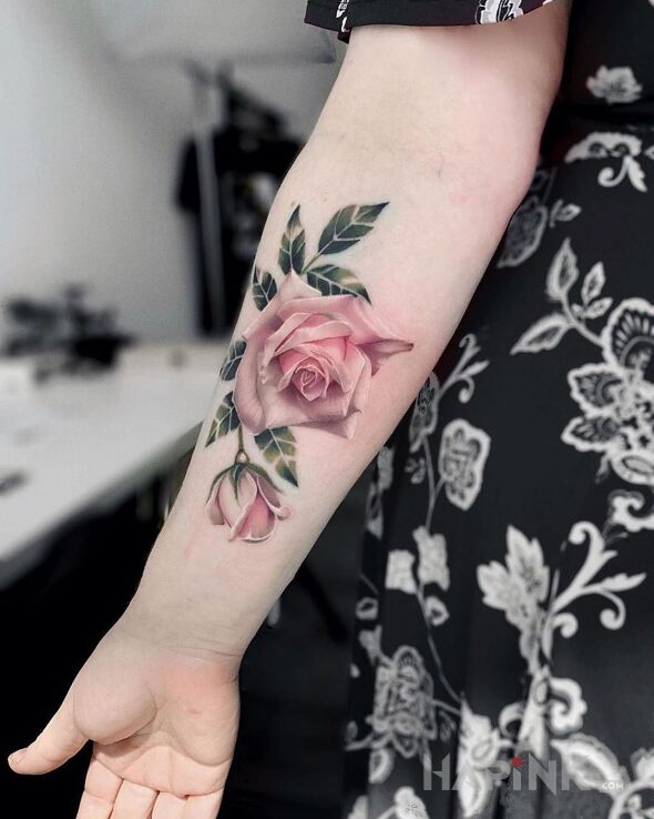 Tattoo Różyczka in flowers motif and realistic style on the forearm