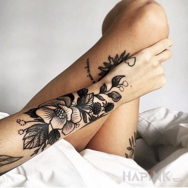 Tattoo Czarny kwiat in flowers motif and graphic / illustrative style on the forearm