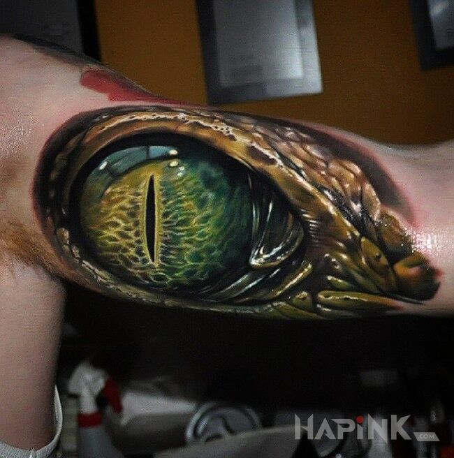 Tattoo Oko krokodyla in realistic style on the upper arm
