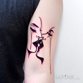 Tattoo Kiss on the upper arm motif: faces style: minimalistic
