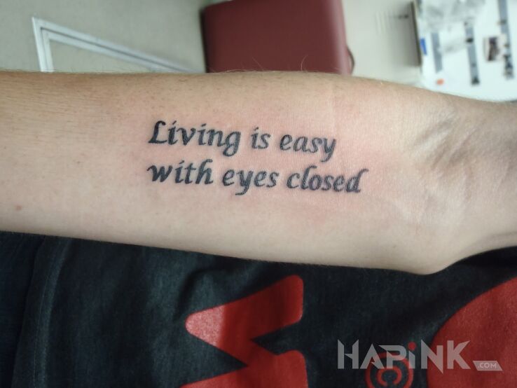 Tattoo Życie z zamkniętymi oczami in lettering motif on the forearm