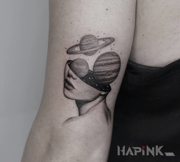 Tattoo Kosmos w głowie in faces motif on the upper arm