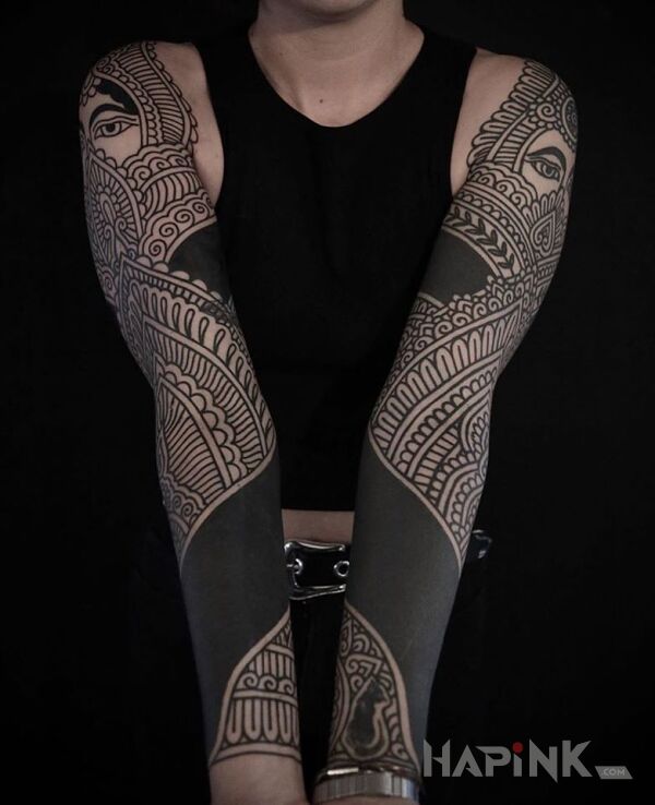 Tattoo Na czarno in ornaments motif and blackwork / blackout style on the upper arm