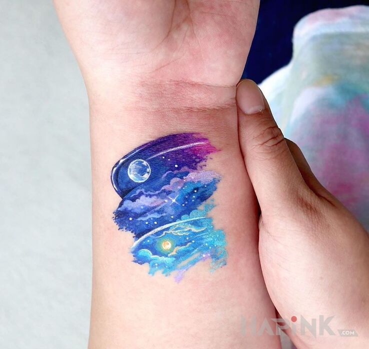 Tattoo Niebo in cosmos motif and Watercolor style on the wrist