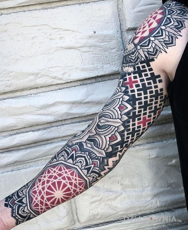 Tatuaż geometryczny czerwono-czarny wzór w motywie mandale i stylu geometryczne na przedramieniu
