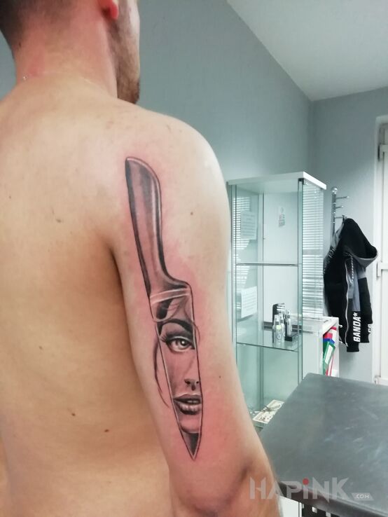 Tattoo Nóż na tricepsie in black and gray motif and graphic / illustrative style on the upper arm