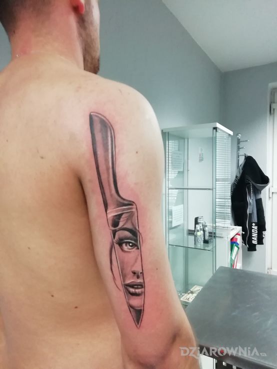 Tatuaż nóż na tricepsie w motywie twarze i stylu graficzne / ilustracyjne na ramieniu