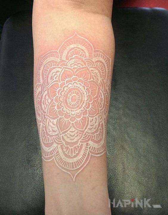 Tattoo Mandala niczym serwetka in mandalas motif and white ink style on the forearm