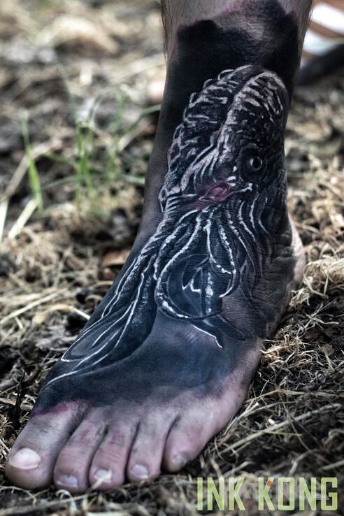 Tattoo Cthulhu in dark motif and realistic style on the foot