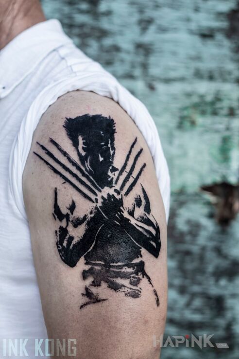 Tattoo Wolverine in black and gray motif and graphic / illustrative style on the upper arm