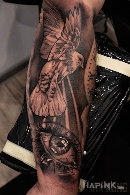 Tattoo Gołębie oczy in black and gray motif and realistic style on the forearm