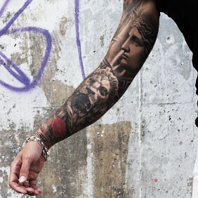Tattoo Lion statue on the upper arm motif: sleeves style: realistic