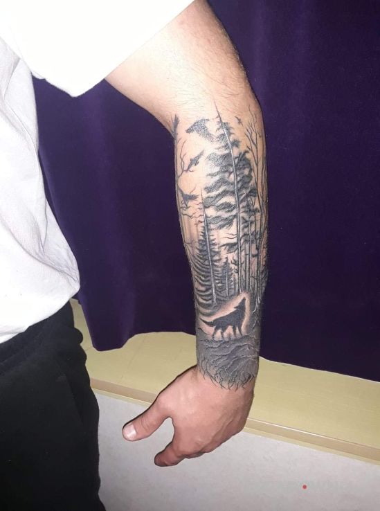 Tatuaż las wilk w motywie czarno-szare i stylu graficzne / ilustracyjne na przedramieniu