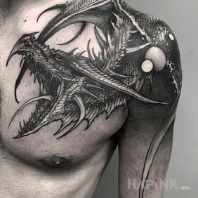 Tattoo Dragon on the upper arm motif: black and gray style: graphic / illustrative