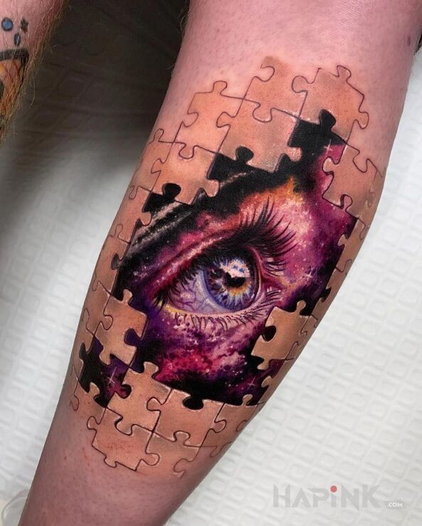 Tattoo Oko pośród puzzli in colorful motif and realistic style on the calf