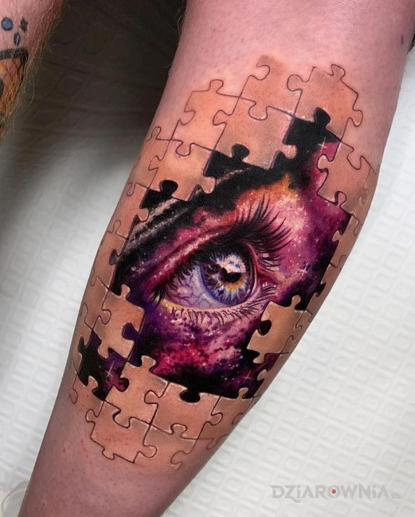 Tatuaż oko pośród puzzli w motywie kolorowe i stylu realistyczne na łydce
