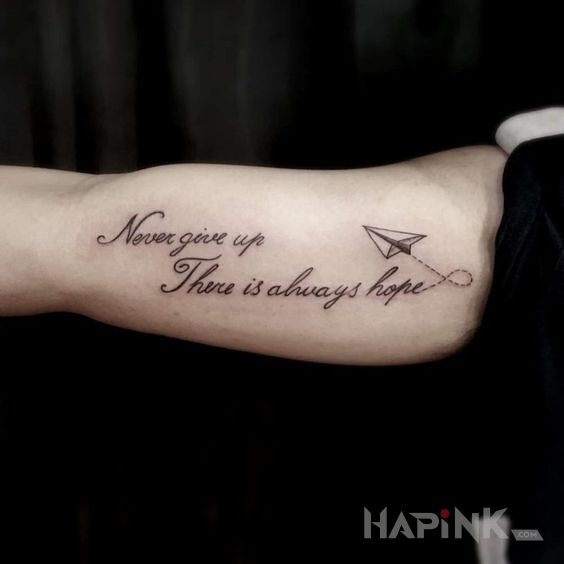 Tattoo Never give up in lettering motif and calligraphy style on the upper arm