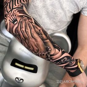 Tatuaż Dłonie z różańcem na przedramieniu motyw: czarno-szare styl: kaligrafia