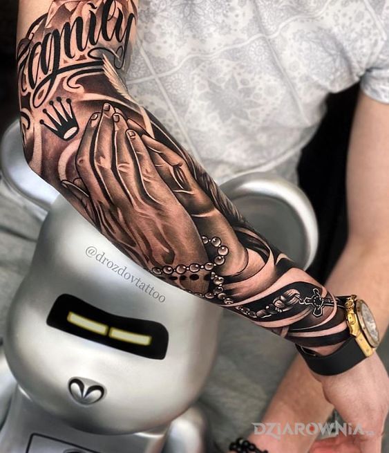 Tatuaż dłonie z różańcem w motywie czarno-szare i stylu kaligrafia na przedramieniu