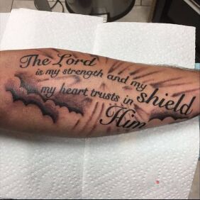 Tattoo Strength and shield on the forearm motif: lettering style: calligraphy
