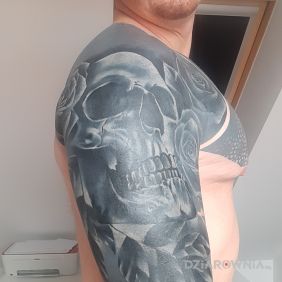 Tatuaż Czaszka na czarno na ramieniu motyw: czarno-szare styl: blackwork / blackout