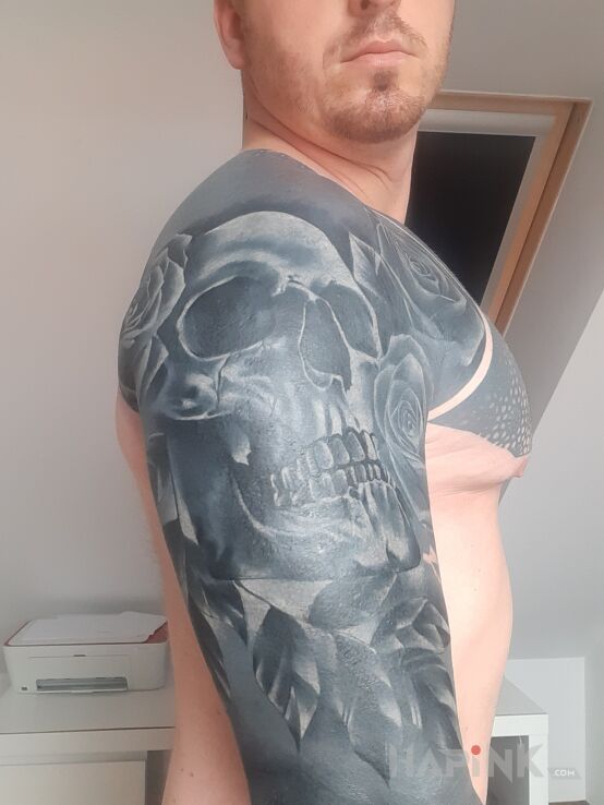Tattoo Czaszka na czarno in skulls motif and blackwork / blackout style on the upper arm