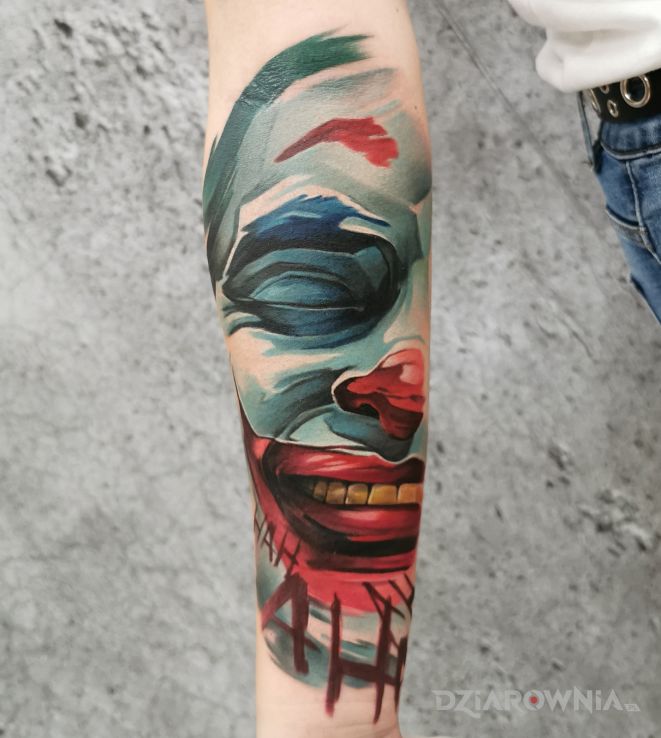 Tatuaż joker w motywie kolorowe i stylu graficzne / ilustracyjne na przedramieniu