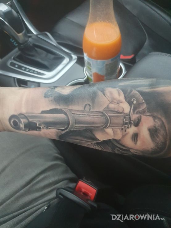 Tatuaż strzelec karabin w motywie czarno-szare i stylu realistyczne na przedramieniu