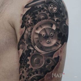 Tattoo Multiple gears on the upper arm motif: ripped skin style: realistic