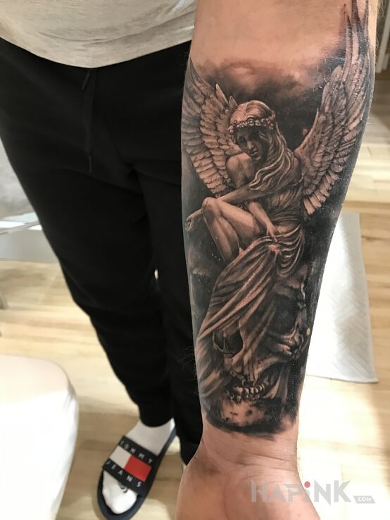 Tattoo Między życiem a śmiercią in angels motif and realistic style on the forearm