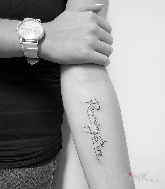 Tattoo Pamiętaj kim jesteś in lettering motif and calligraphy style on the forearm