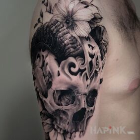 Tattoo Skull with horns, connection to vegetation on the upper arm motif: flowers style: realistic