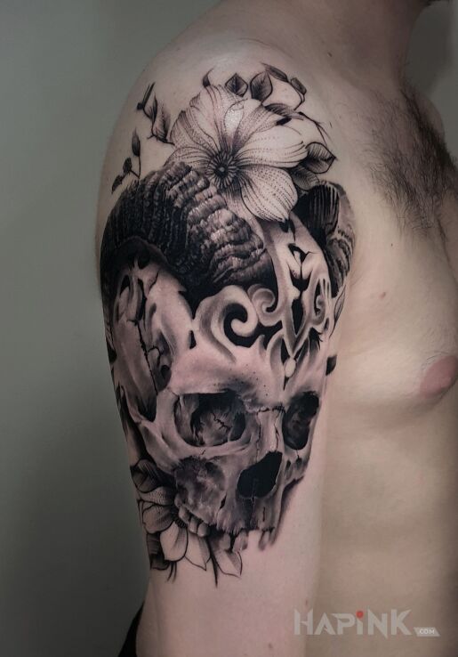 Tattoo Czaszka z rogami, połączenie z roślinnością in flowers motif and realistic style on the upper arm