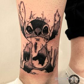 Tatuaż Stich na nodze motyw: czarno-szare styl: kreskówkowe / komiksowe