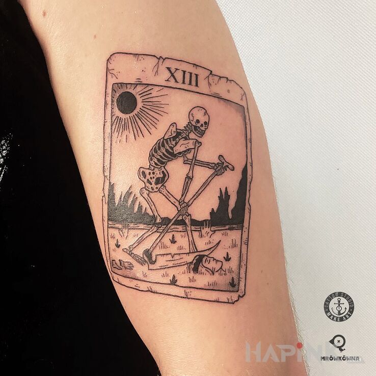 Tattoo Karta tarota in skulls motif and engravings / gravure style on the upper arm