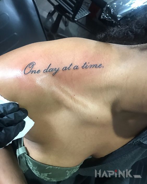 Tattoo Jeden dzien na raz in lettering motif and calligraphy style on the collarbone