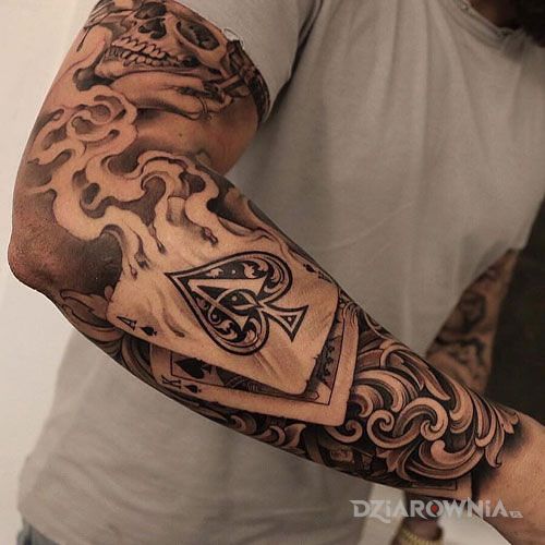 Tatuaż dymiący as w motywie czaszki i stylu realistyczne na przedramieniu