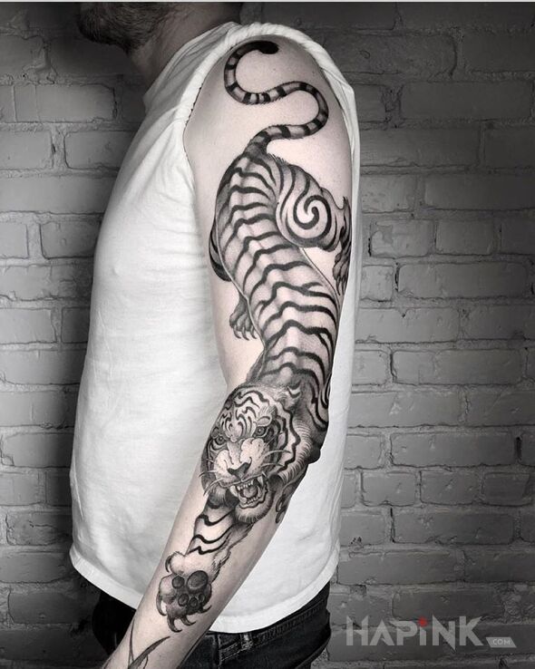 Tattoo Big tiger in black and gray motif and graphic / illustrative style on the upper arm