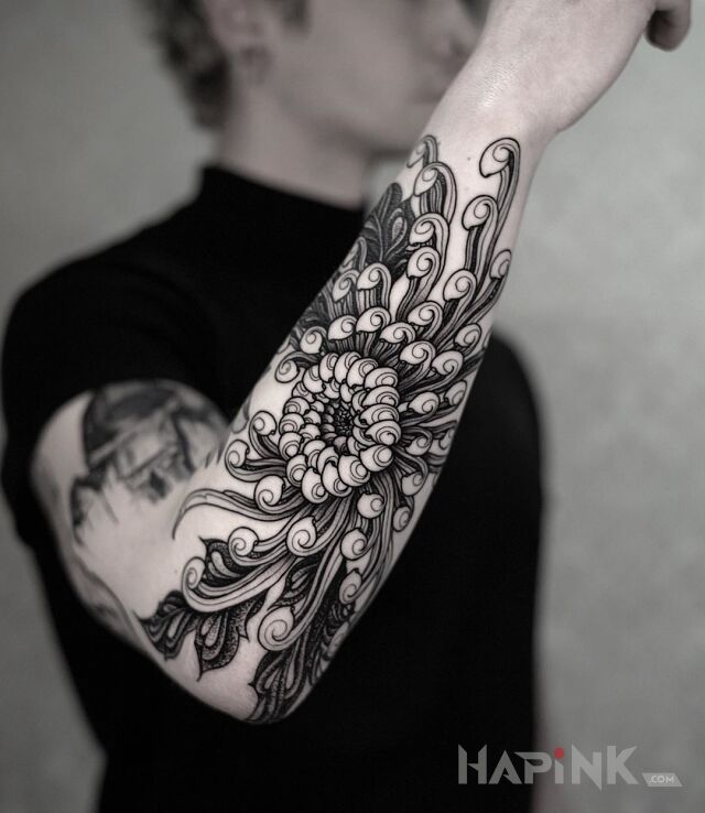 Tattoo Chryzantema in black and gray motif and graphic / illustrative style on the forearm