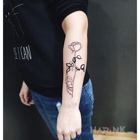 Tattoo Skull on the forearm motif: black and gray style: contour / linework