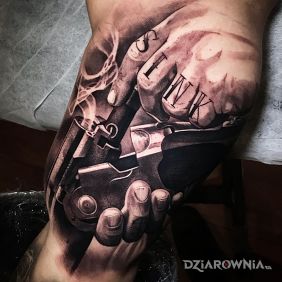 Tatuaż Ładowanie strzelby na ramieniu motyw: czarno-szare styl: realistyczne